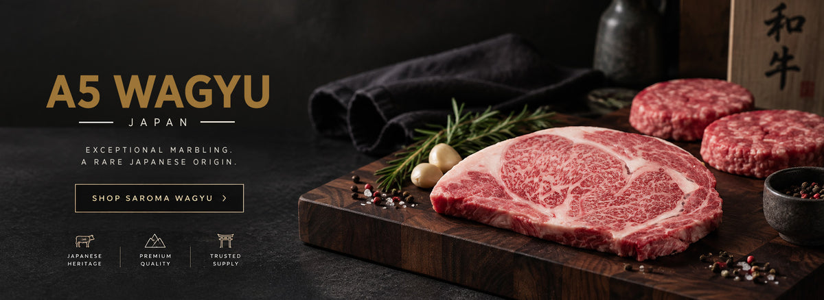 A5 Wagyu beef steaks and ground meat displayed on a dark wooden cutting board with rosemary, garlic, and spices, set against a dark background with promotional text reading 'A5 WAGYU JAPAN'.
